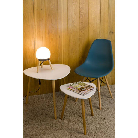 Holz Tischlampe MINE Weiß, Braun auf einem Tisch neben einem blauen Stuhl und Magazinen.