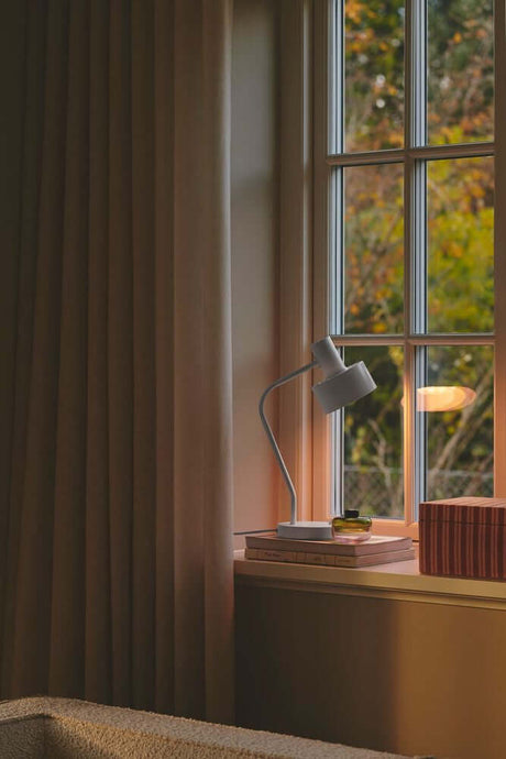 Bordlampe Matis på en vinduskarm, ideell for skrivebord og minimalistisk innredning.