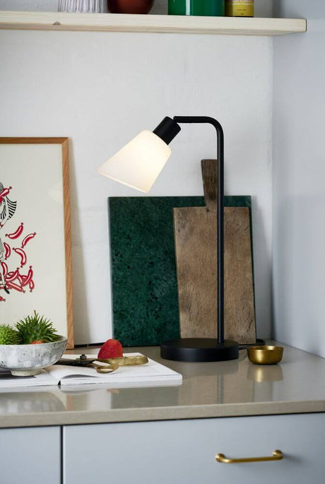 Tischlampe Molli in Schwarz mit weißem Schirm auf einem modernen Sideboard