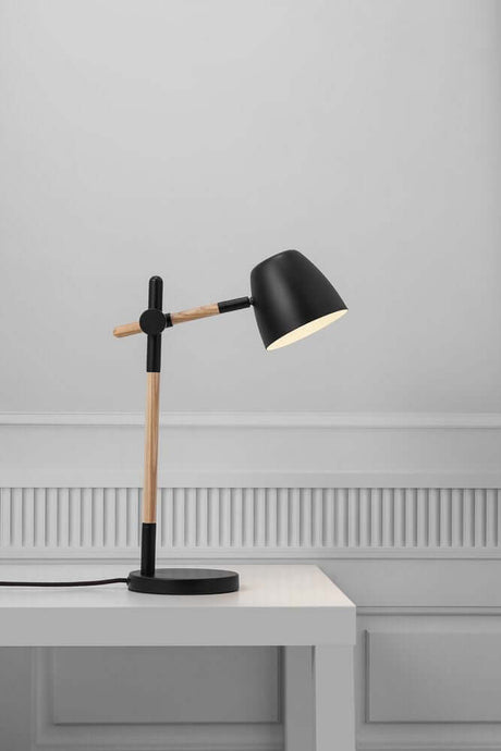 Theo bordlampe i moderne design med en kombination af træ og metal på et bord.
