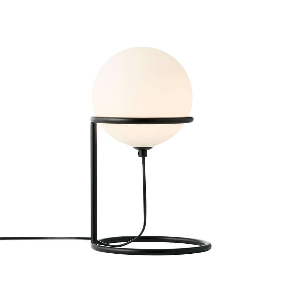 Tischlampe Wilson mit schwarzem Metallrahmen und rundem Glasschirm, der sanftes Licht verbreitet.