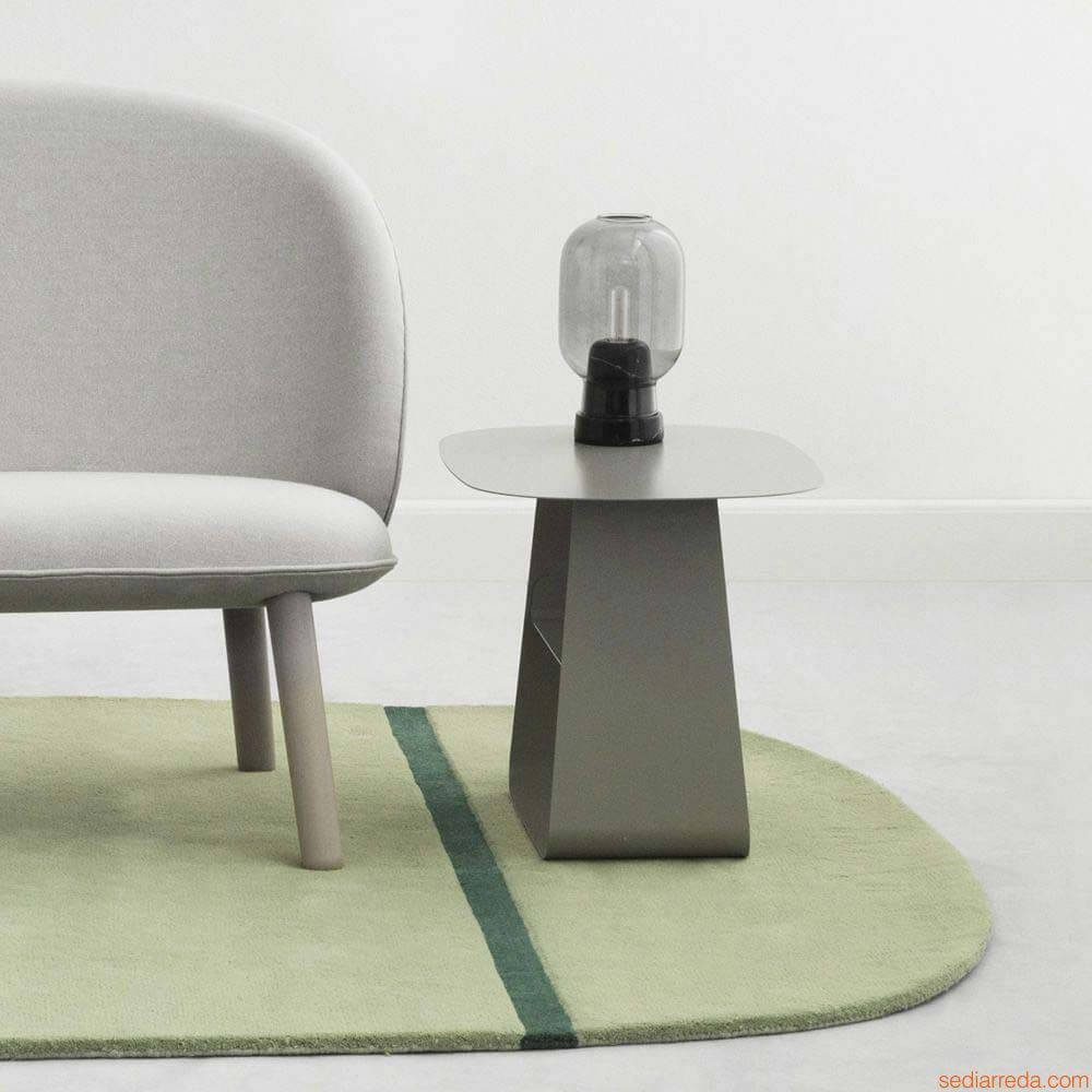 Tischleuchte Amp im Skandi-Look Rauchglas auf einem modernen Beistelltisch mit grauem Sofa und grünem Teppich.