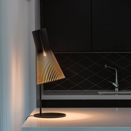 Secto 4220 table lamp made of wood, 75 cm, on a modern table with a black background.