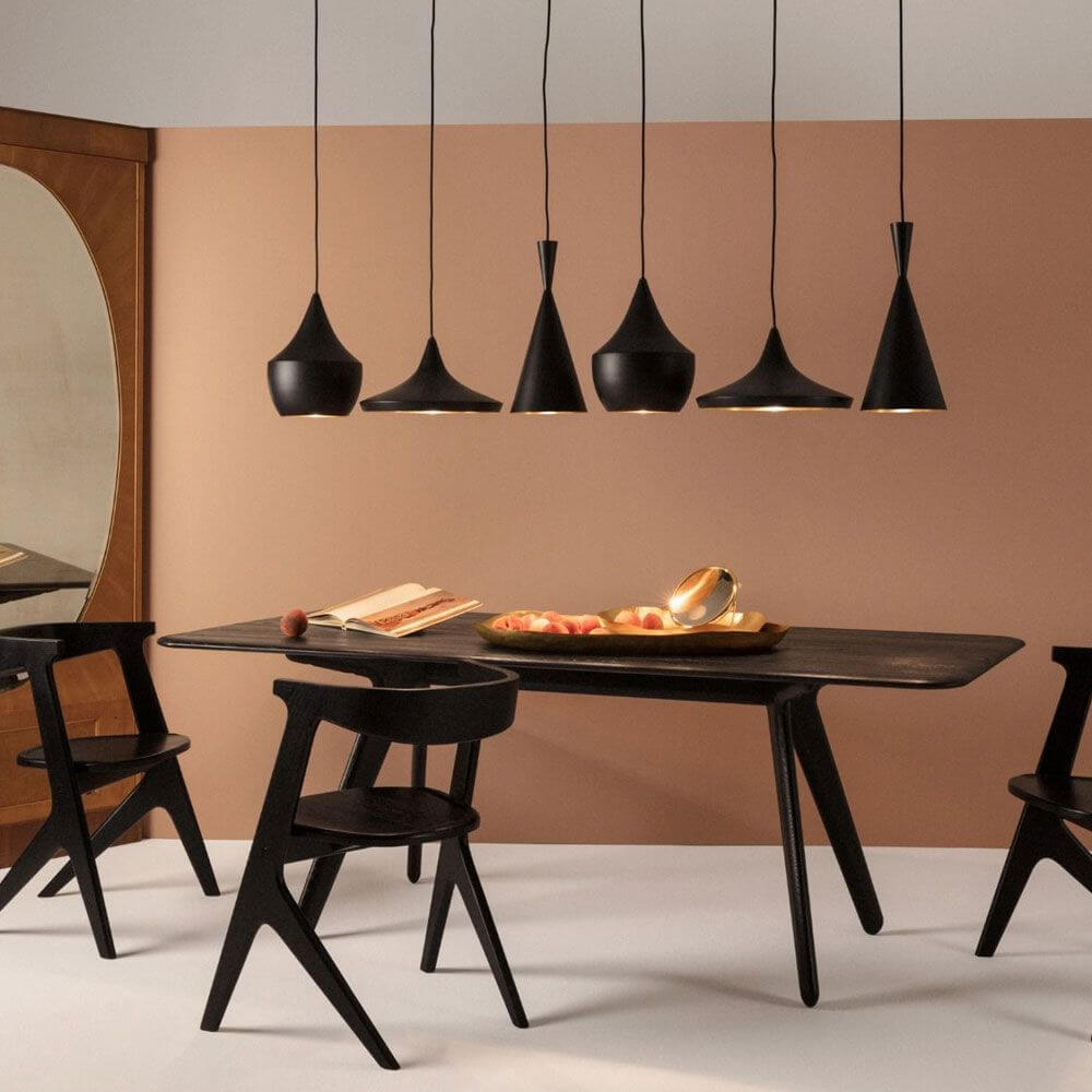 Tom Dixon Beat Pendelleuchten in Schwarz über modernem Esstisch, stilvolle Inneneinrichtung mit dramatischen Elementen.