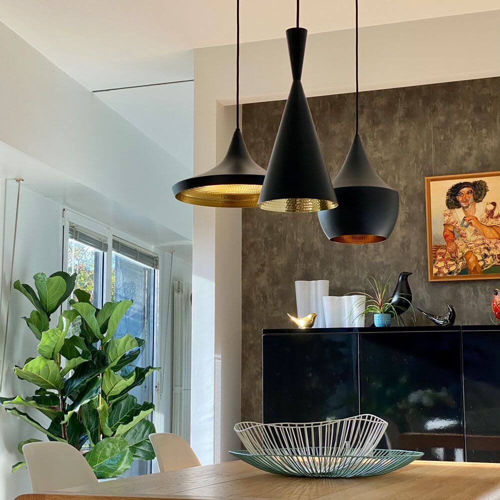 Tom Dixon Beat Wide LED Hängeleuchte in modernem Wohnraum mit grünem Pflanzenakzent.