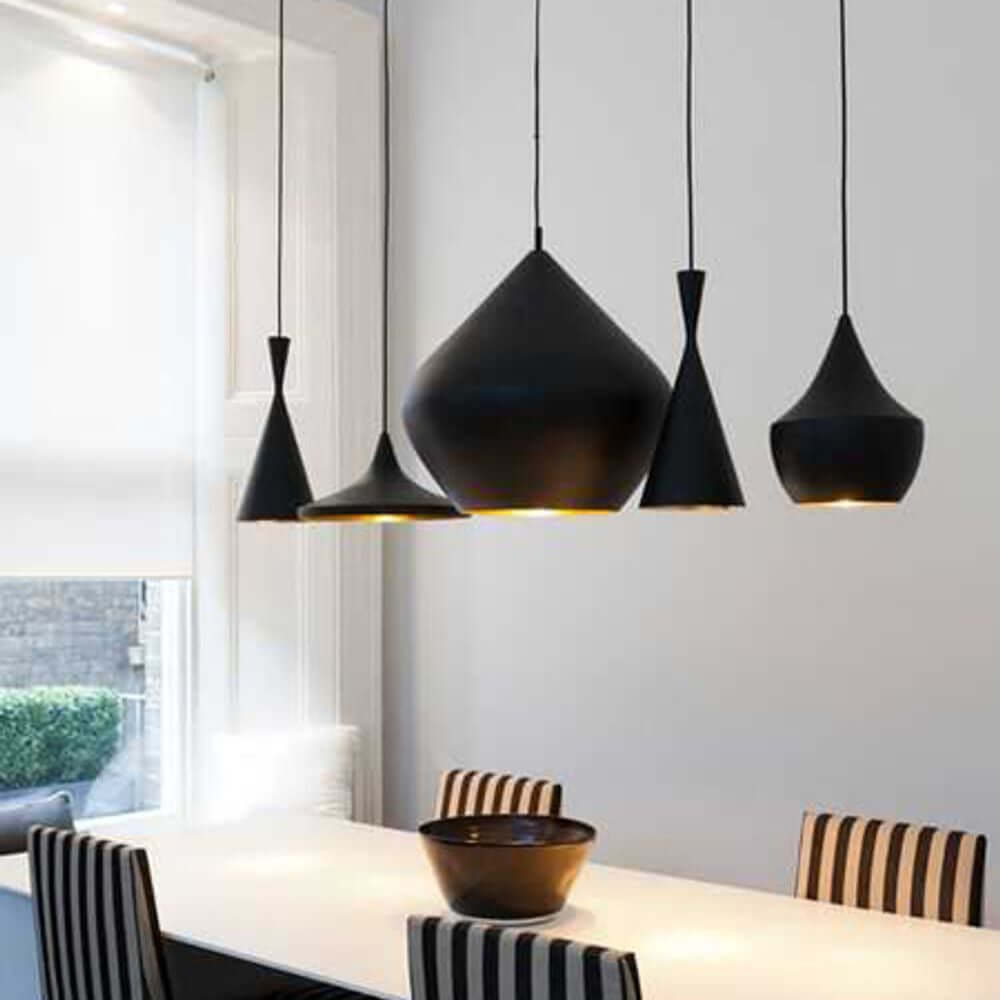 Tom Dixon Beat Wide LED Hängeleuchte Ø 36cm in modernem Interieur mit mehreren Leuchten über dem Tisch.