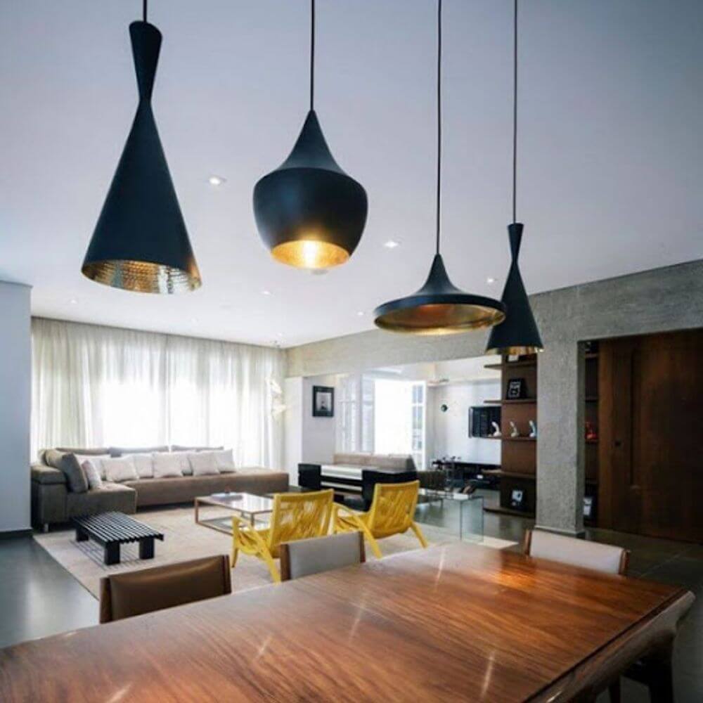 Moderner Essbereich mit Tom Dixon Beat Wide Hängeleuchten in Schwarz und Gold, stilvolles Interieur und natürliche Beleuchtung.
