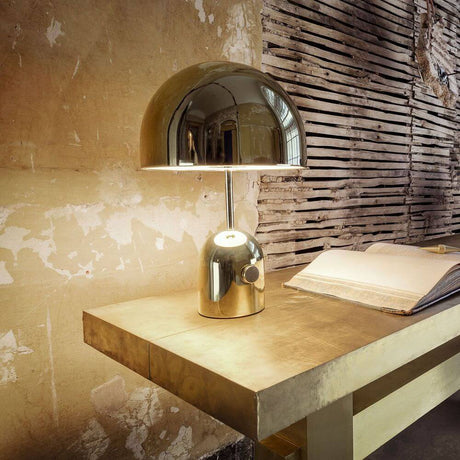 Tom Dixon Bell Tischleuchte mit Drehdimmer auf einem eleganten Tisch, poliertes Design und stabiler Fuß.