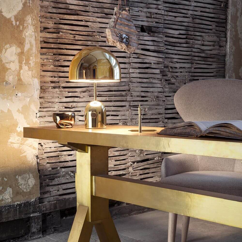 Tom Dixon Bell Tischleuchte mit Drehdimmer auf einem eleganten Tisch in modernem Innenraum.