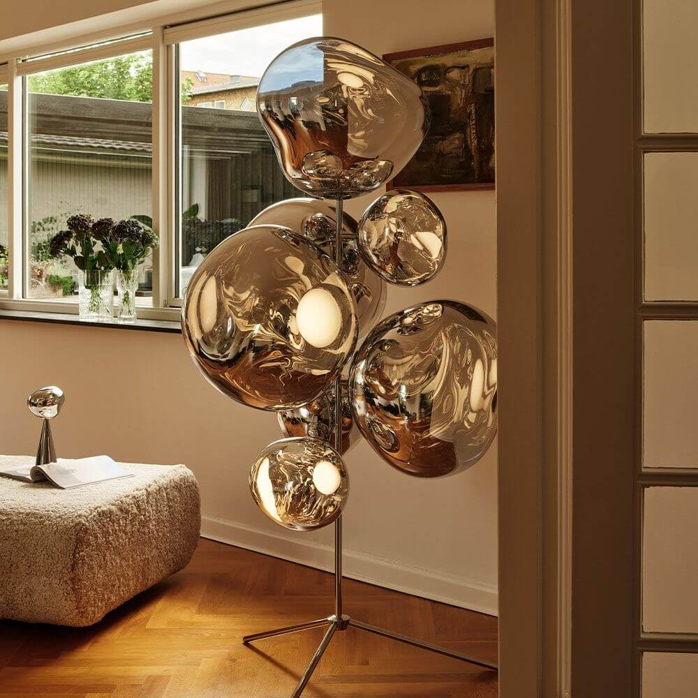 Tom Dixon Melt Stehleuchte mit glänzenden, deformierten Lichtglobusen im Wohnraum.