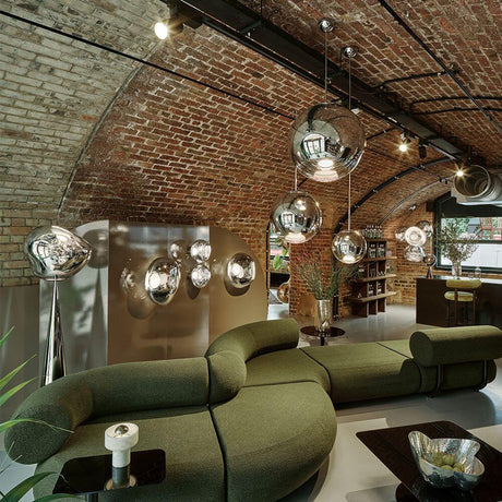 Tom Dixon Mirror Ball LED Spiegelkugel Hängeleuchte in modernem Wohnambiente mit Ziegelsteinwand.