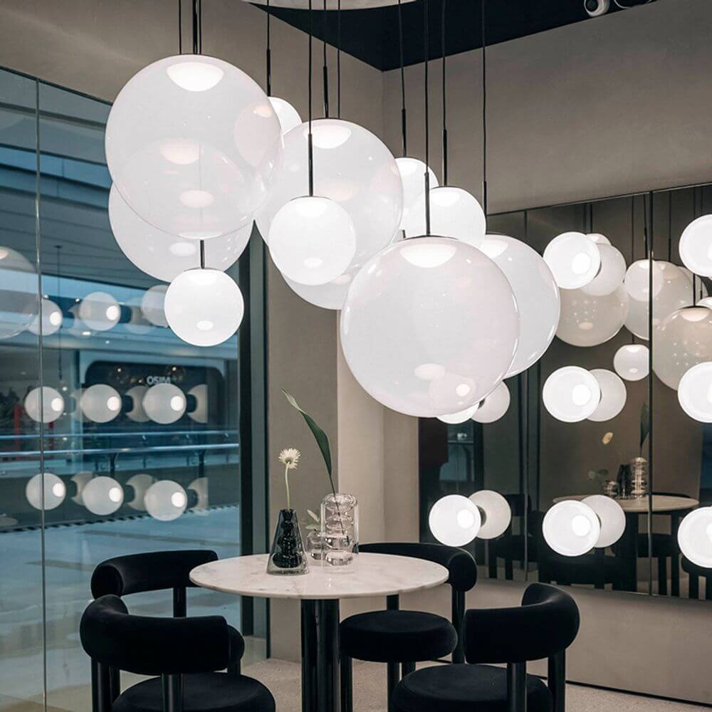 Tom Dixon Opal Kugelleuchte Pendel in modernem Raum mit minimalistischer Einrichtung.