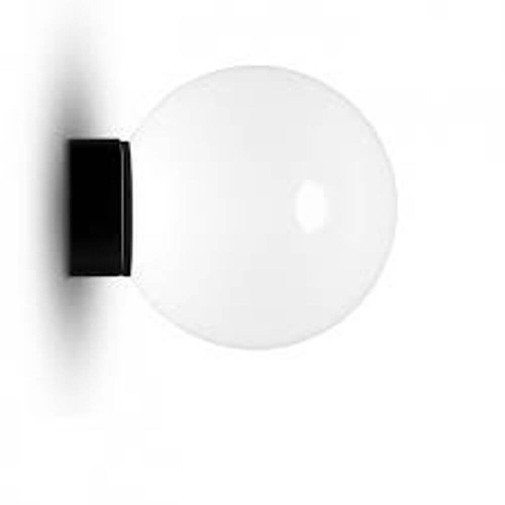 Tom Dixon Opal Wandleuchte Ø 25cm in minimalistischer, runder Form an Wand montiert.