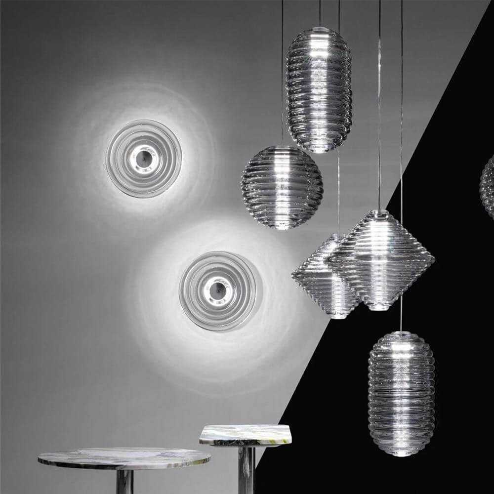 Tom Dixon Press Innen- & Außen-Wandleuchte mit hellem Licht, kombiniert mit pendelnden Leuchten im modernen Design.