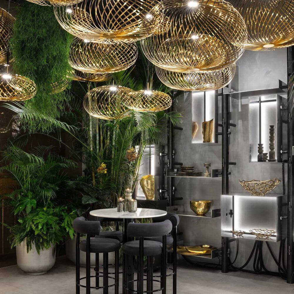 Tom Dixon Spring LED Hängelampe ausziehbar in modernem Interieur mit Pflanzen und eleganter Tischanordnung.