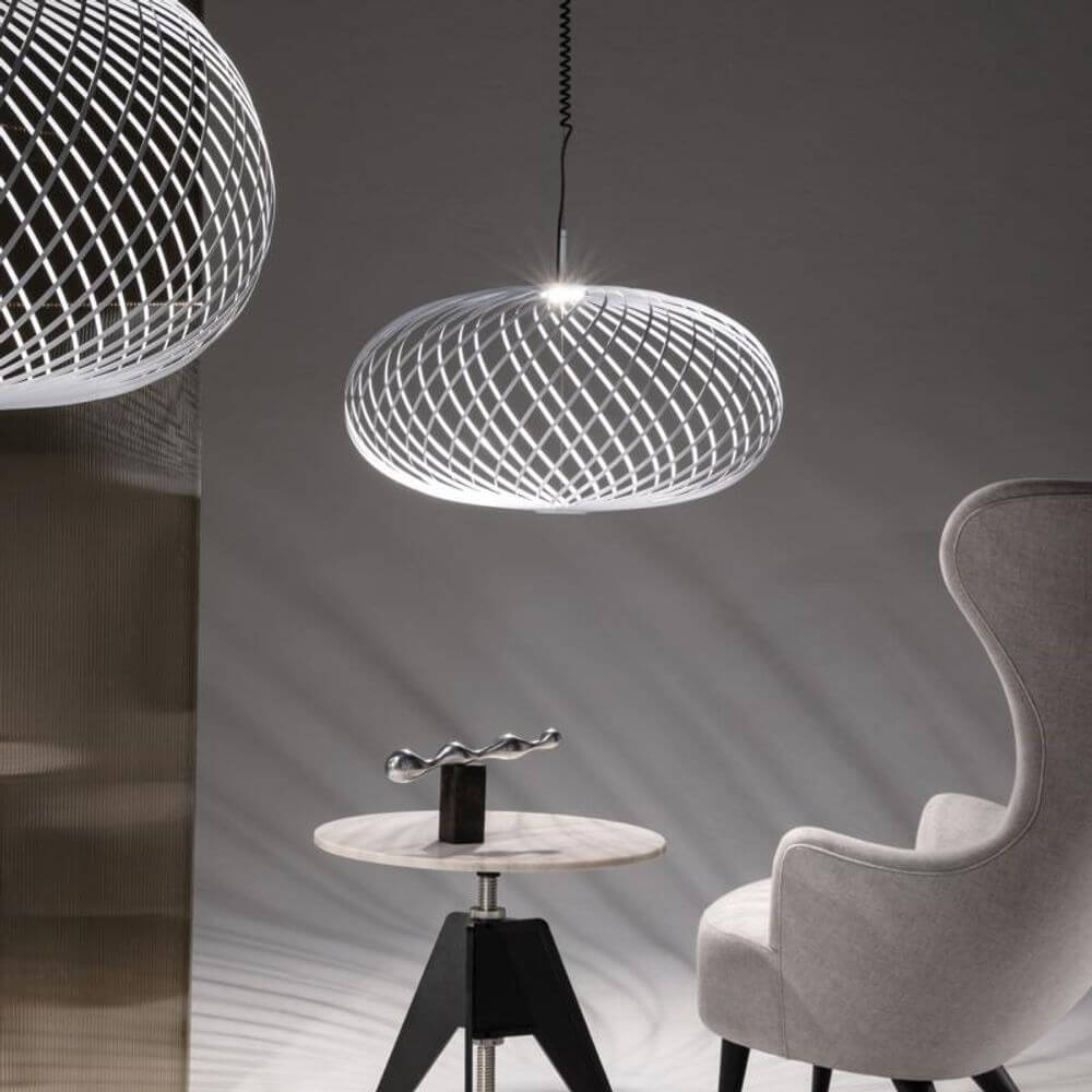 Tom Dixon Spring LED Hängelampe ausziehbar über einem modernen Tisch und Stuhl in einem stilvollen Raum.