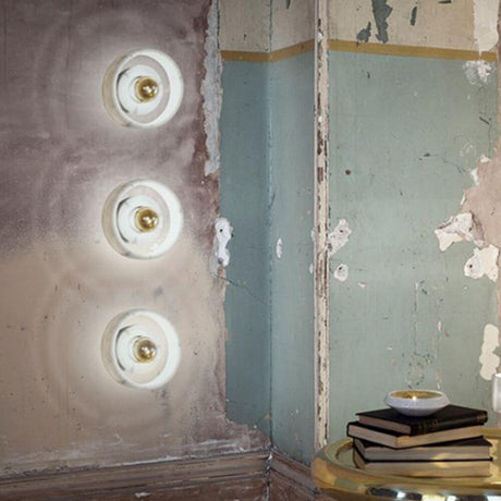 Tom Dixon Stone Wandlampe aus Marmor an einer Wand in einem rustikalen Raum.