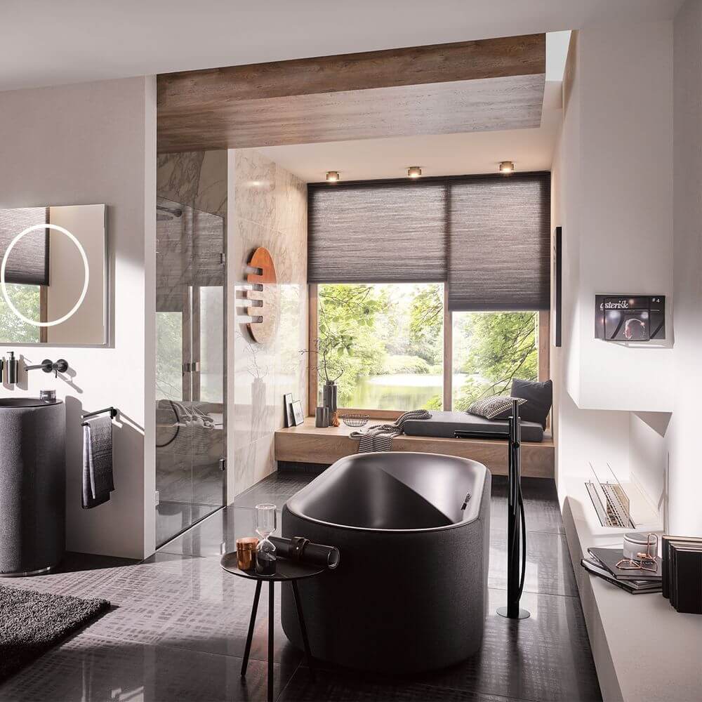 Elegant Badezimmer mit LED Deckenstrahler Puk Maxx Move 360°, freistehender Badewanne und Blick ins Grüne.