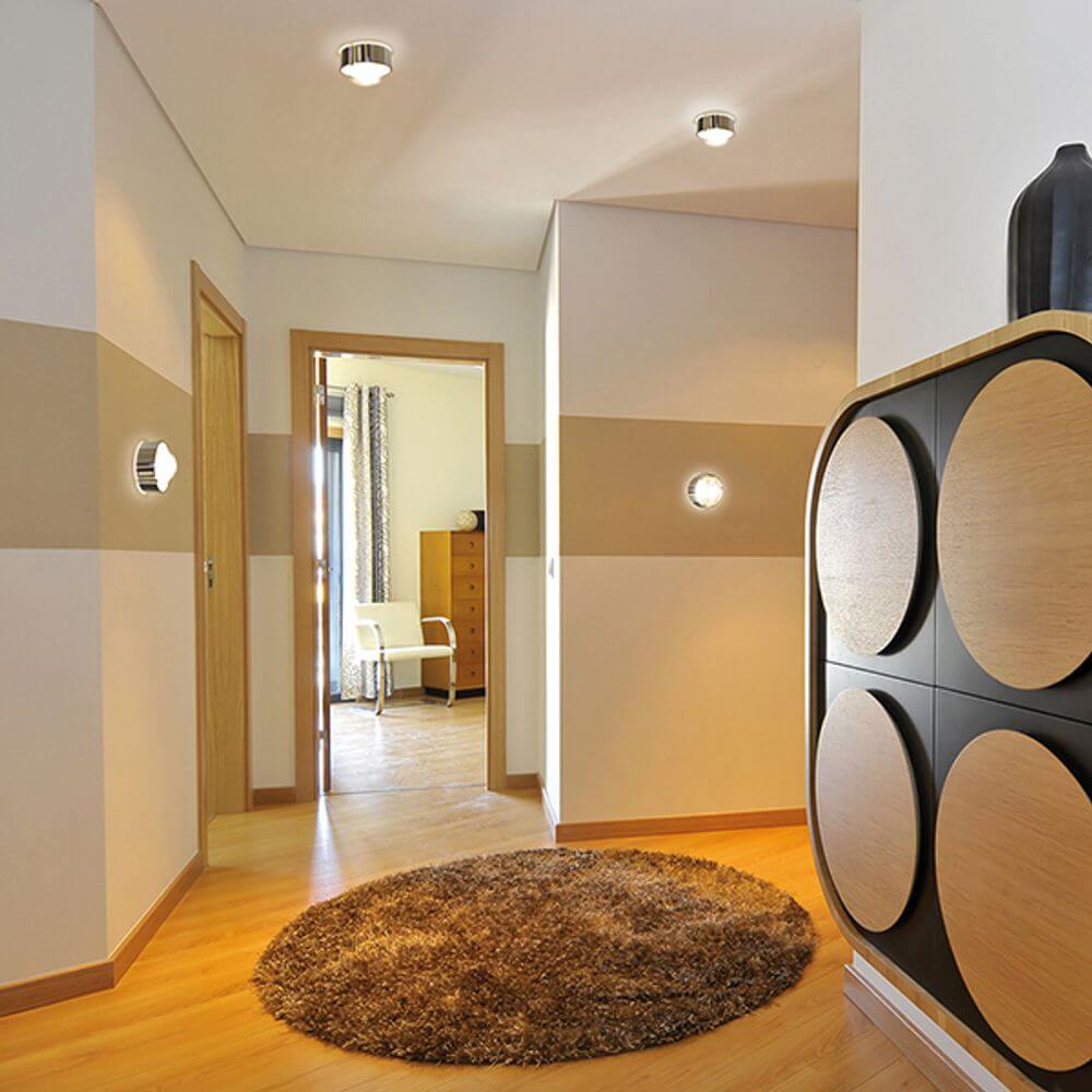 LED Deckenleuchte Puk Maxx One 2 in modernem Flur mit Holz- und Teppichdetails.