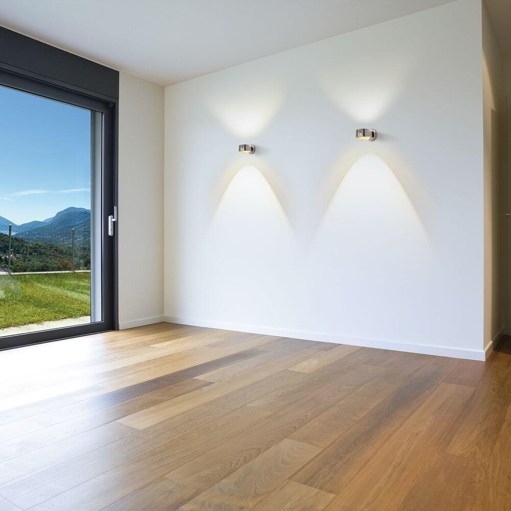 LED Wandleuchte Puk Maxx Wall Dimmbar in einem modernen Raum mit Blick auf die Natur.