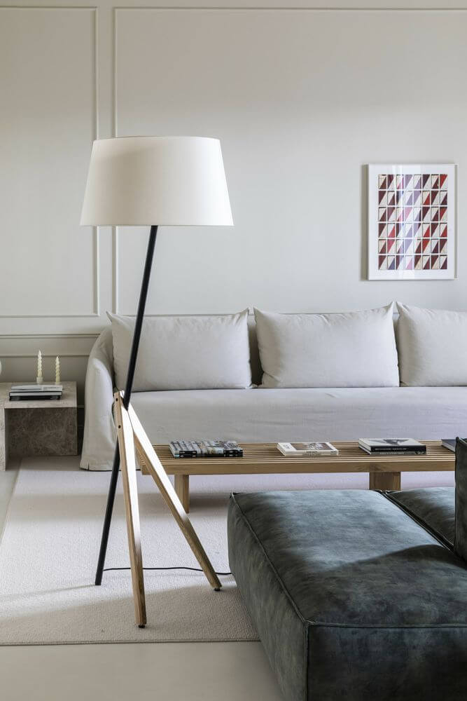 Treewood Stehlampe Esche in modernem skandinavischem Wohnzimmer mit hellem Sofa und Holz-Tisch.