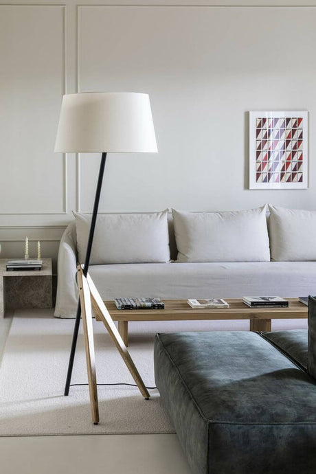 Treewood floor lamp in ash in a modern Scandinavian living room with a light-colored sofa and wooden table.