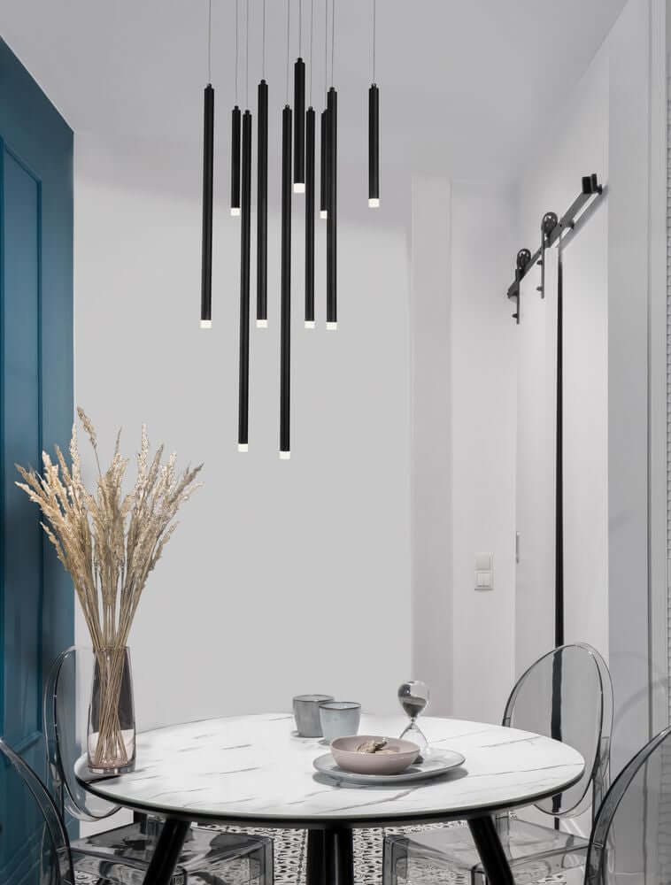 Moderne Trimle LED Pendelleuchte mit zylinderförmigen Elementen über einem eleganten Esstisch.