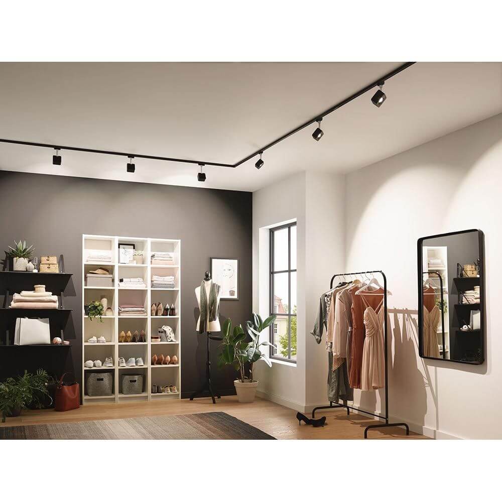 U-Rail LED Schienenspot Cube Spot Schwarz-Matt Dimmbar in einem modernen Raum mit Kleidung und Regalen.