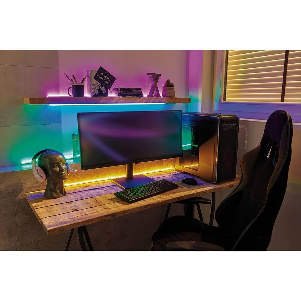 USB-LED Strip Neon Colorflex Blau 1m leuchtet stilvolles Gaming-Setup mit Monitor und Schreibtisch.
