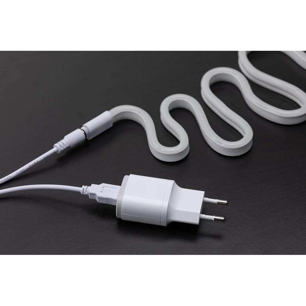 USB-LED Neon Strip in Grün mit Stecker und Kabel in geschwungener Form auf schwarzem Hintergrund
