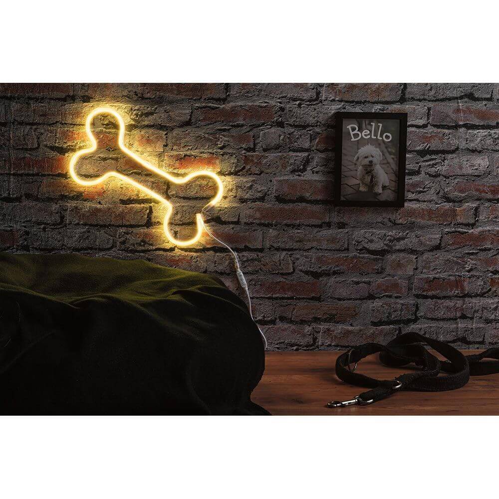 Neon-Licht in Knochenform auf Ziegelwand mit Hundeleine und Bilderrahmen für kreative Dekoration.