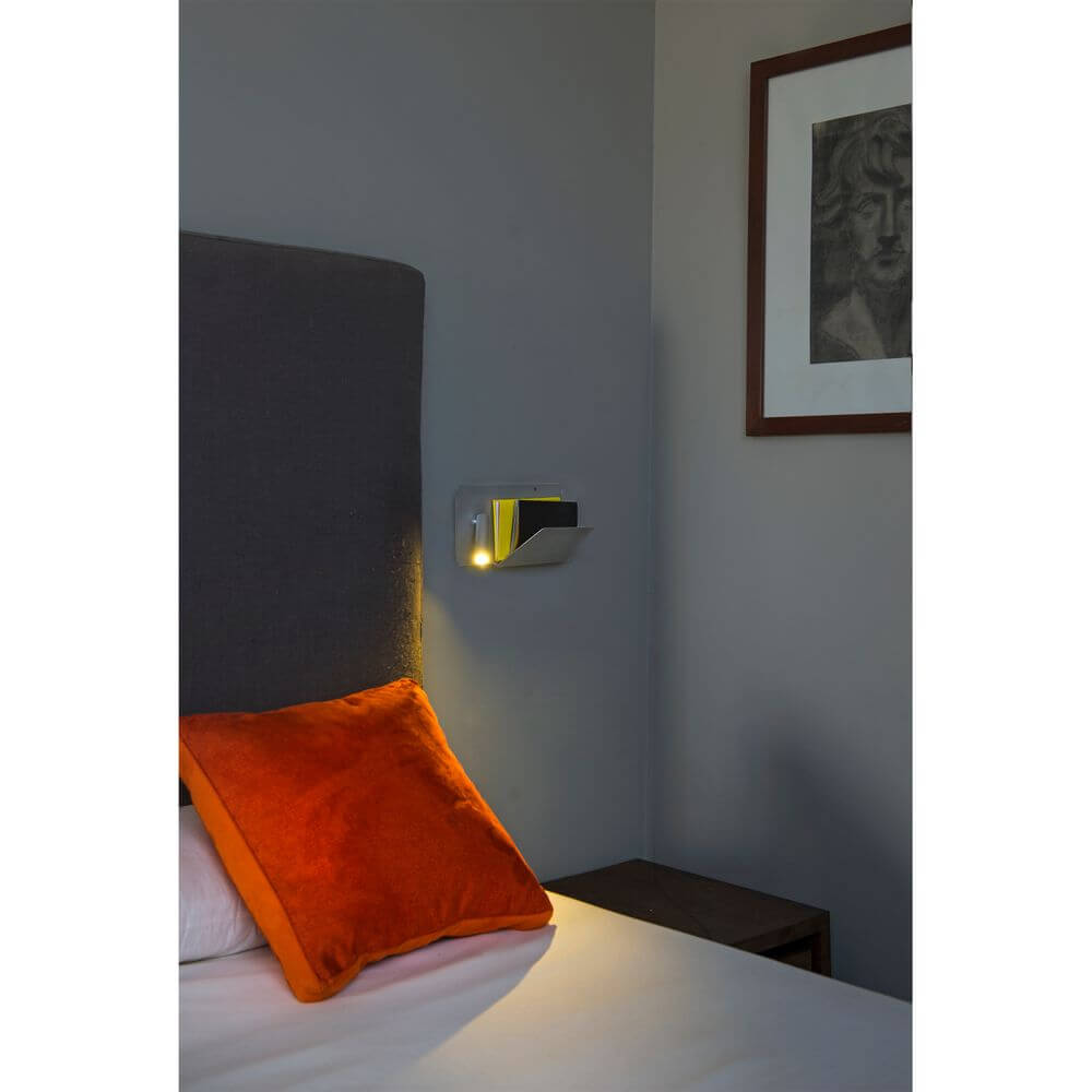 USB Wandlampe SUAU mit linken LED-Lesespot Grau an einer Wand über einem Bett.