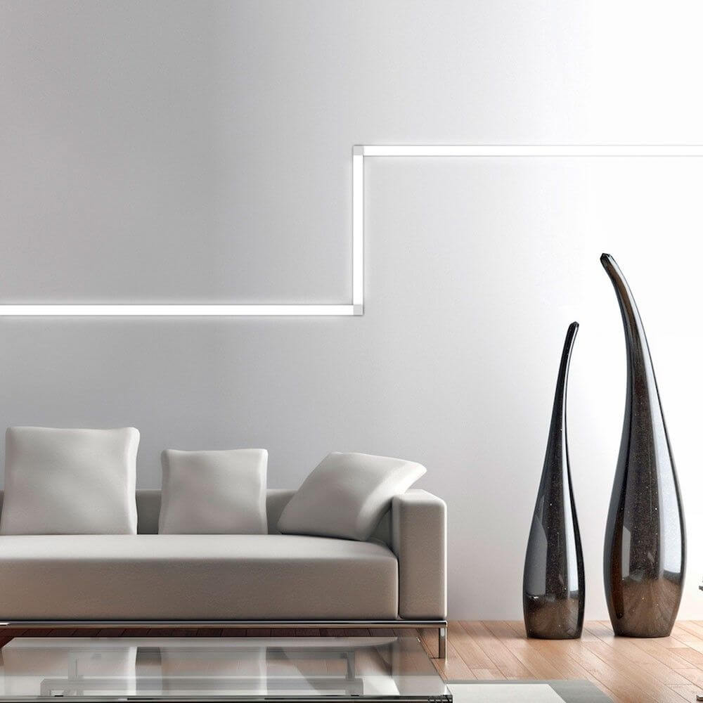 VIGO System LED-Linienmodul 100cm Alu-matt an einer Wohnzimmerwand mit eleganter Sofagarnitur und Vasen.