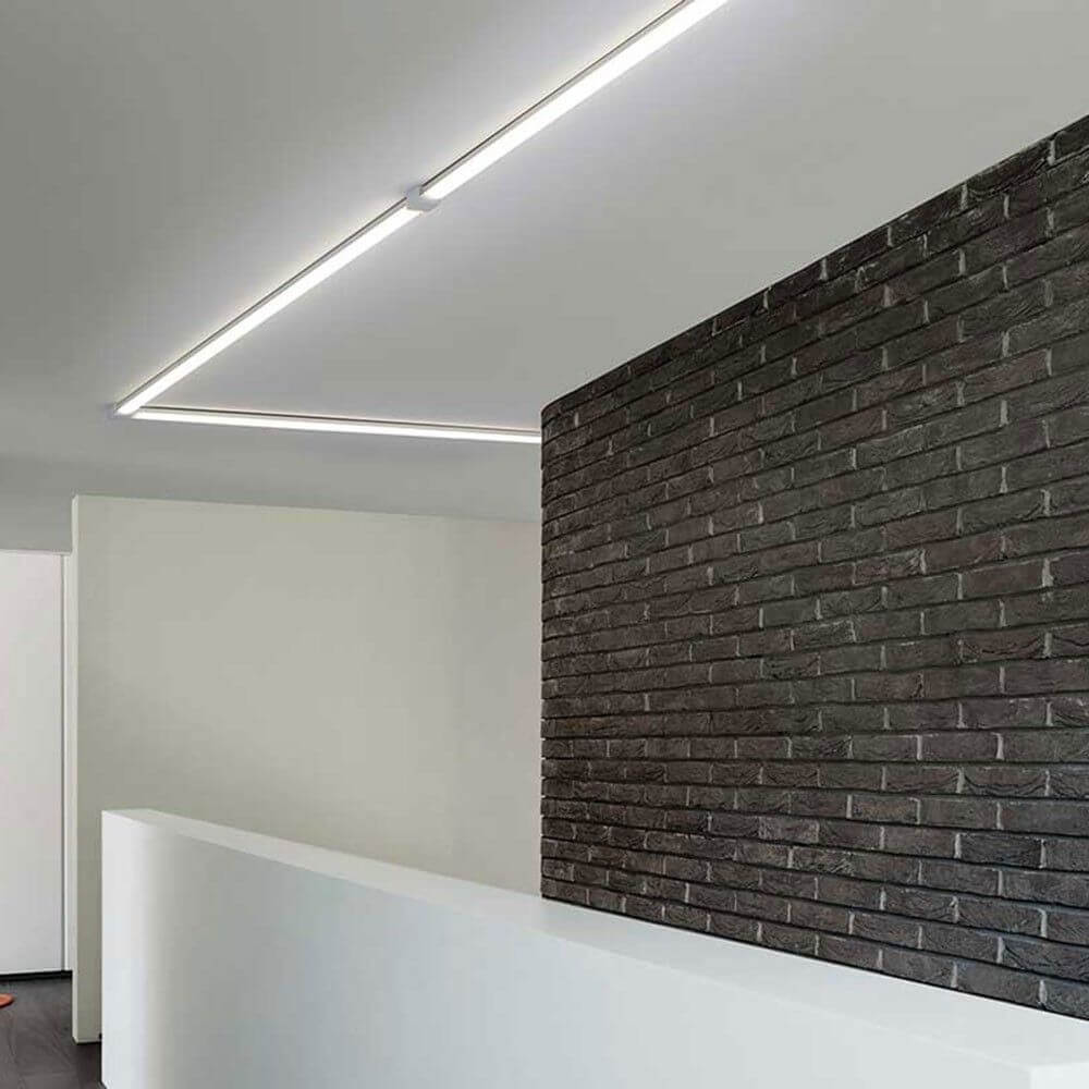VIGO System LED-Linienmodul 100cm Alu-matt an einer modernen Wand mit Ziegelstein.