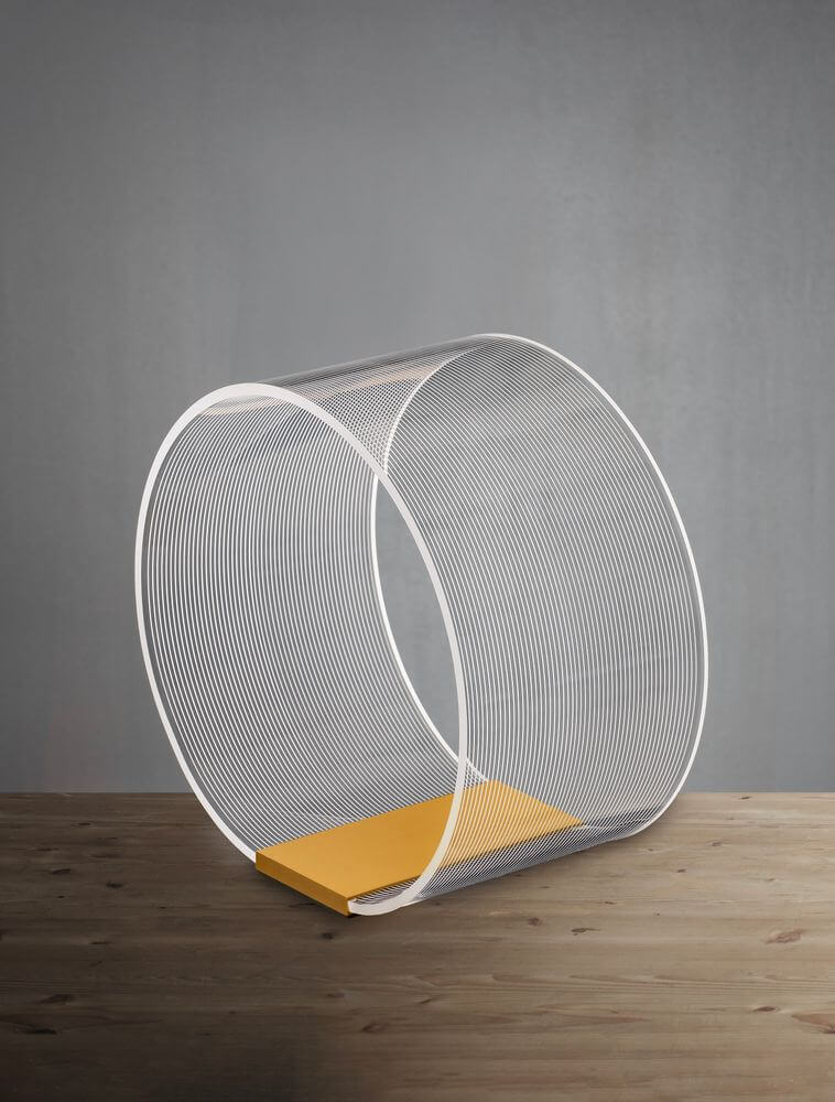Valentin LED Tischleuchte Ø 28cm 3000K Gold auf einem Holzuntergrund mit gelbem Akzent.
