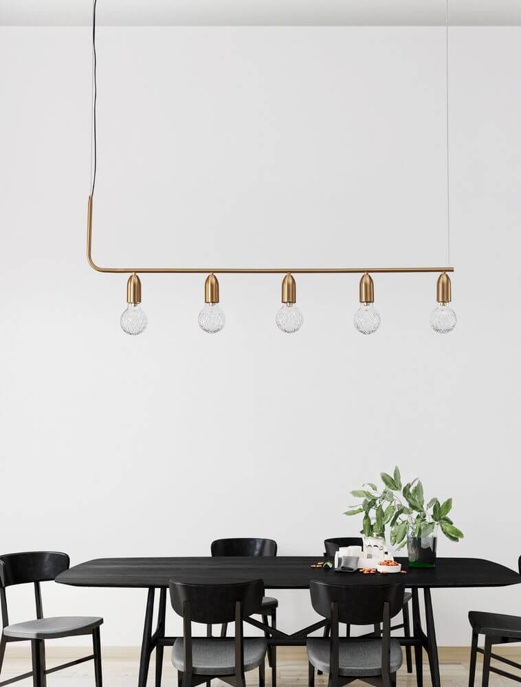 Moderne Veda Pendelleuchte mit fünf Glaskugeln in geometrischem Design über einem schwarzen Esstisch.