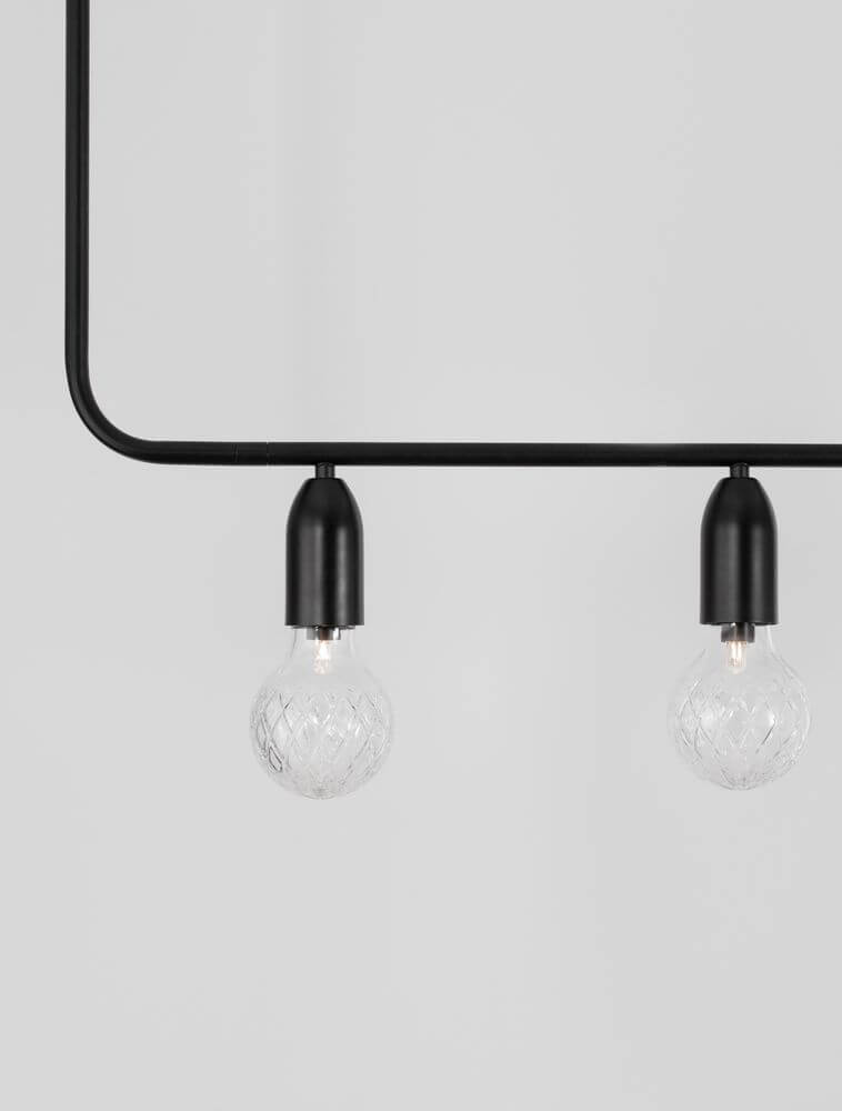 Detailansicht der Veda Pendelleuchte mit zwei klaren Glaskugeln und schwarzem Rahmen, modernes Design.