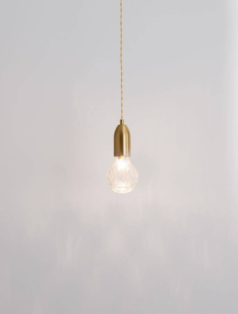 Pendelleuchte in Gold mit durchsichtigem Lampenschirm, ideal für elegante Innenräume.