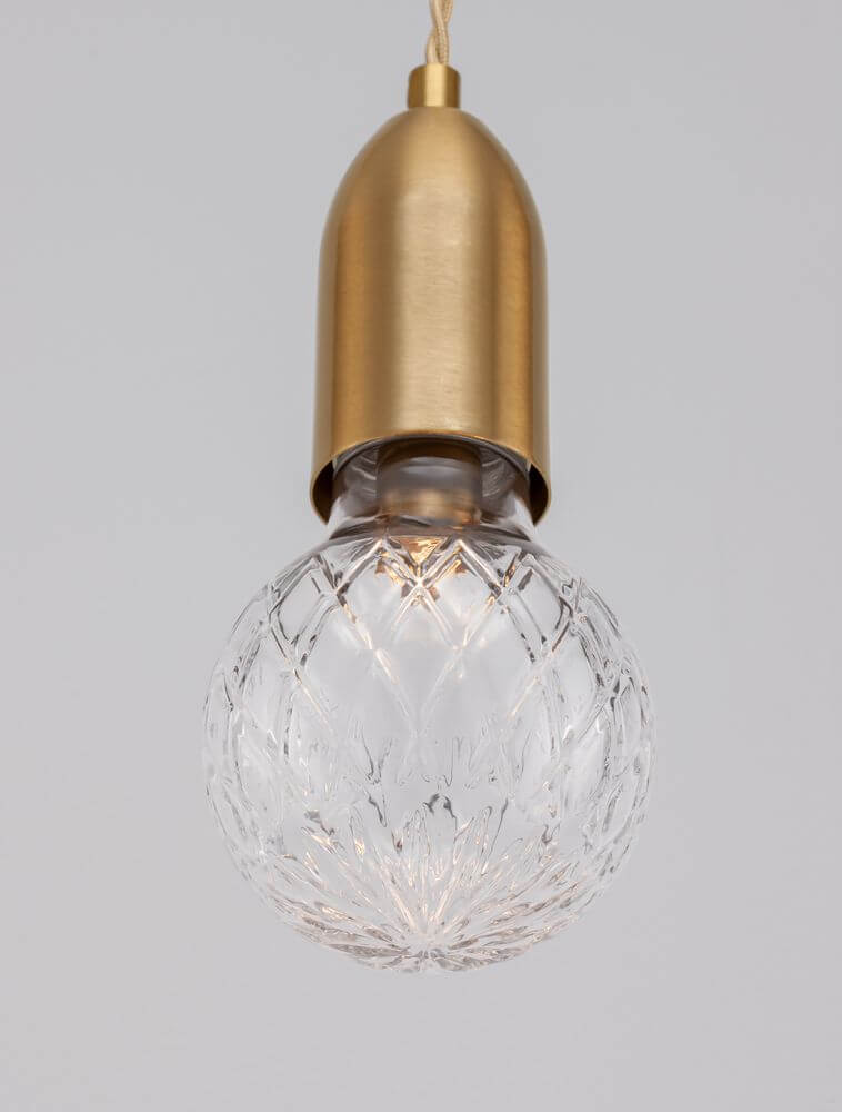 Elegante Pendelleuchte mit goldfarbener Fassung und kristallklarem Lampenschirm in einzigartigem Design.