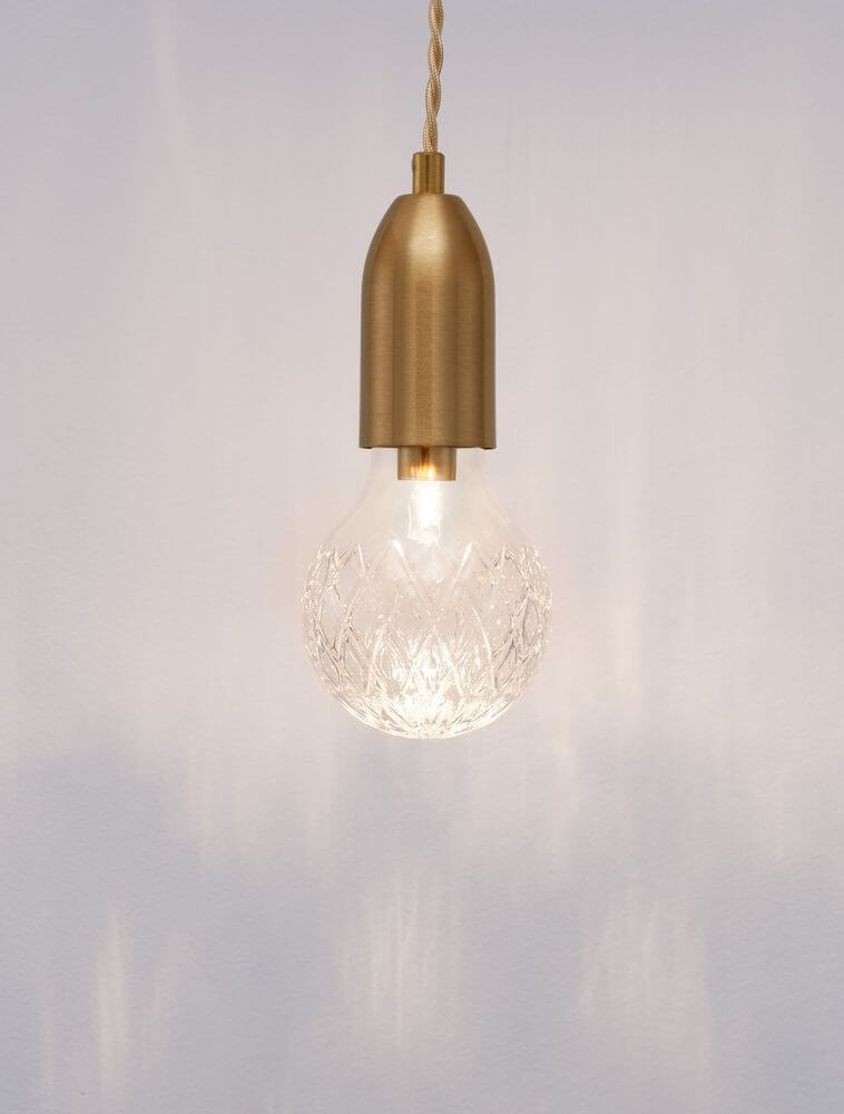 Pendelleuchte aus Messing mit gläserner Lampe, schafft stilvolle Beleuchtung für moderne Innenräume.