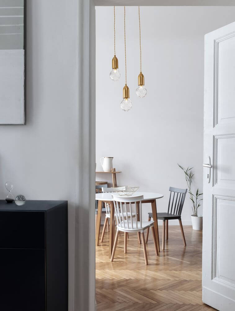 Veda Pendelleuchte G9 mit drei Glühbirnen im modernen Essbereich mit Holz-Esstisch und stilvollen Stühlen.