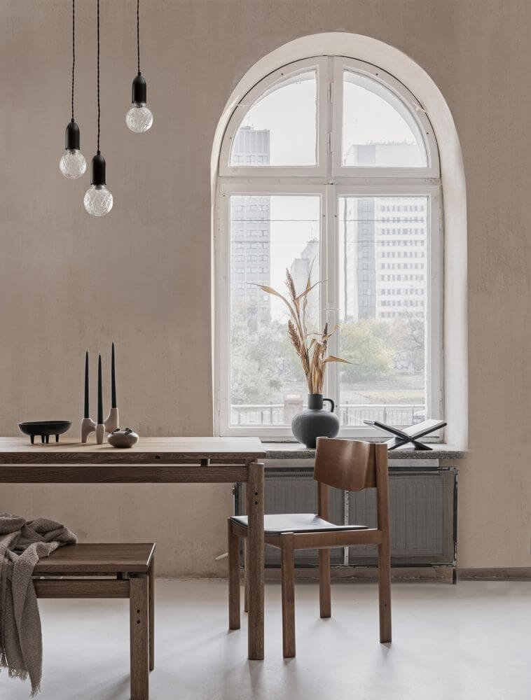 Modernes Esszimmer mit Holzstuhl, Tisch, eleganten Pendelleuchten und einem großen Fenster.