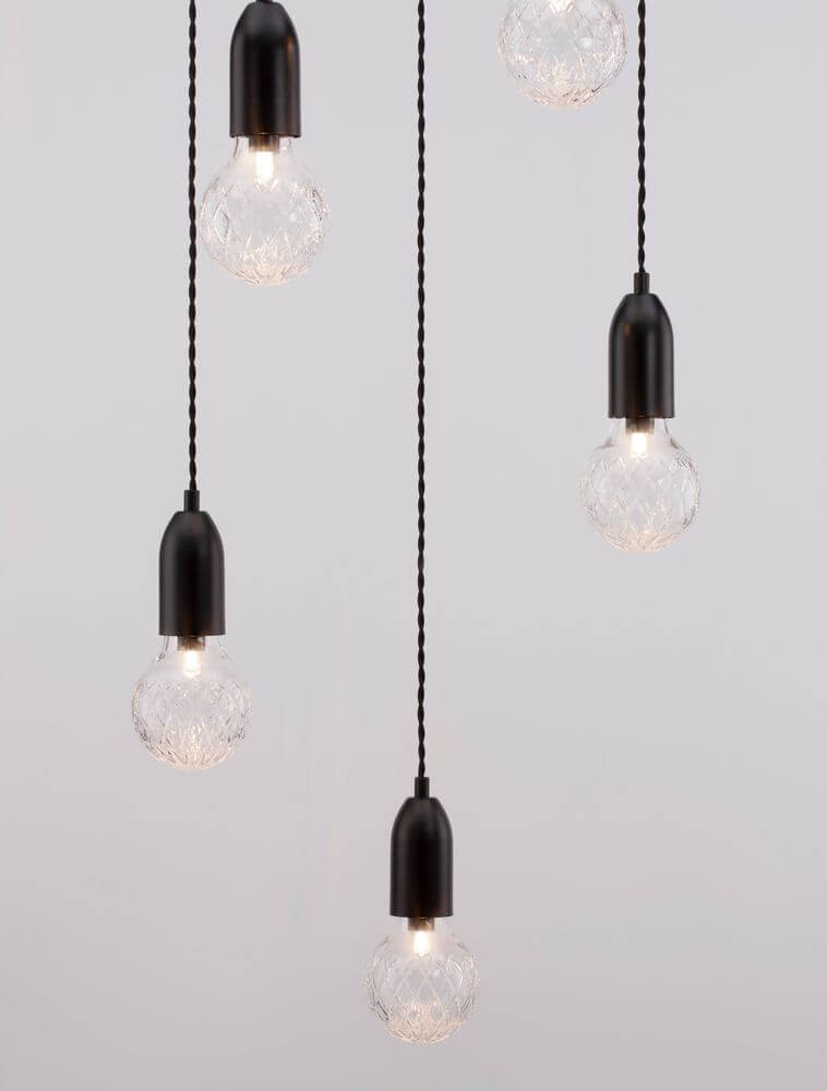 Elegante Veda Pendelleuchte G9 mit fünf handgeschliffenen Kristallschirmen und schwarzen Aufhängungen.