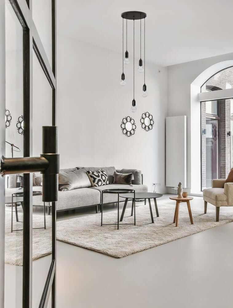 Gemütliches Wohnzimmer mit stilvoller Pendelleuchte, modernen Möbeln und hellen Farben.