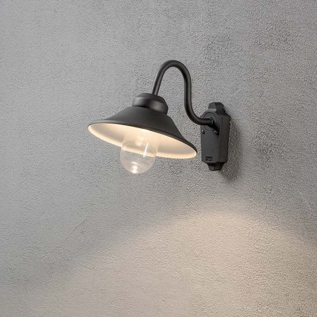 Vega LED outdoor wall light 700lm, 3000K black, clear glass mounted on a wall with warm light.
