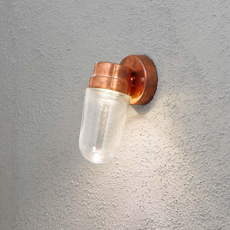Vega LED Außen-Wandleuchte 700lm , 3000K massives Kupfer, klares Glas an einer Wand montiert.