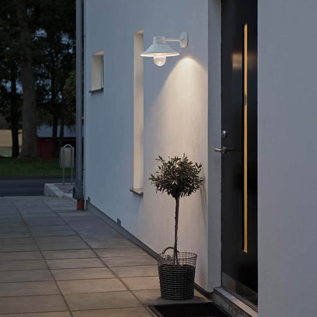 Vega LED outdoor wall light white, clear glass on a modern house wall with a potted plant.