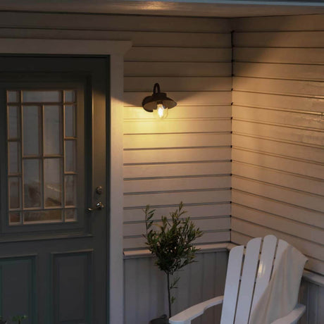 Vega Mini outdoor wall light on a wall next to an entrance door with a comfortable chair.