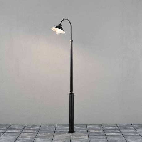 Vega vloerlamp Zwart, helder glas staat elegant in de ruimte met zwart glanzend metaal en een helder lampenkap.