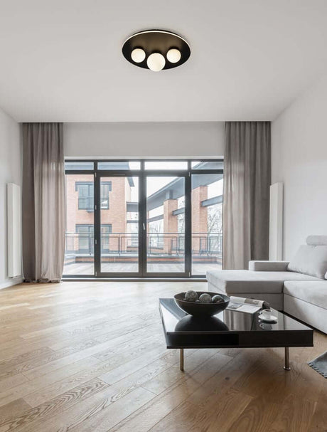 Velna LED 3-light ceiling light Ø 49.5 cm 3000K Black in a modern living room with large windows.